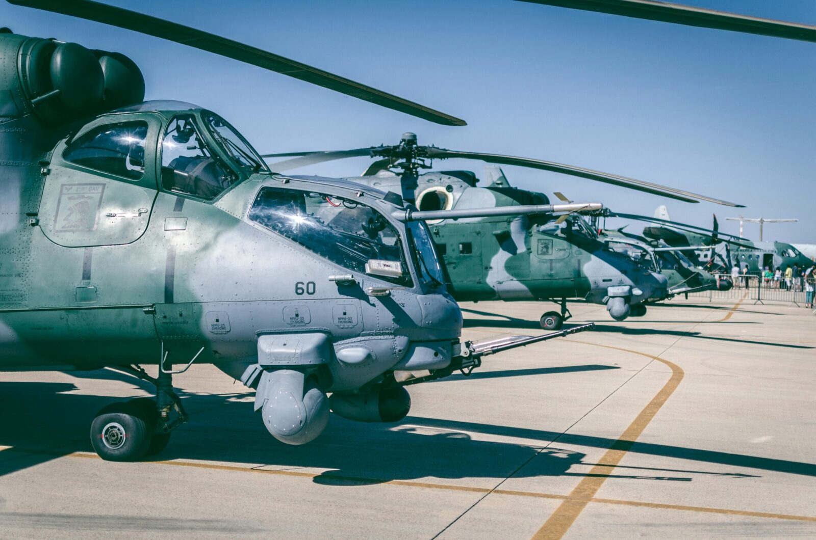 Line of military helicopters on an airfield under clear blue skies in Brasília, Brazil.